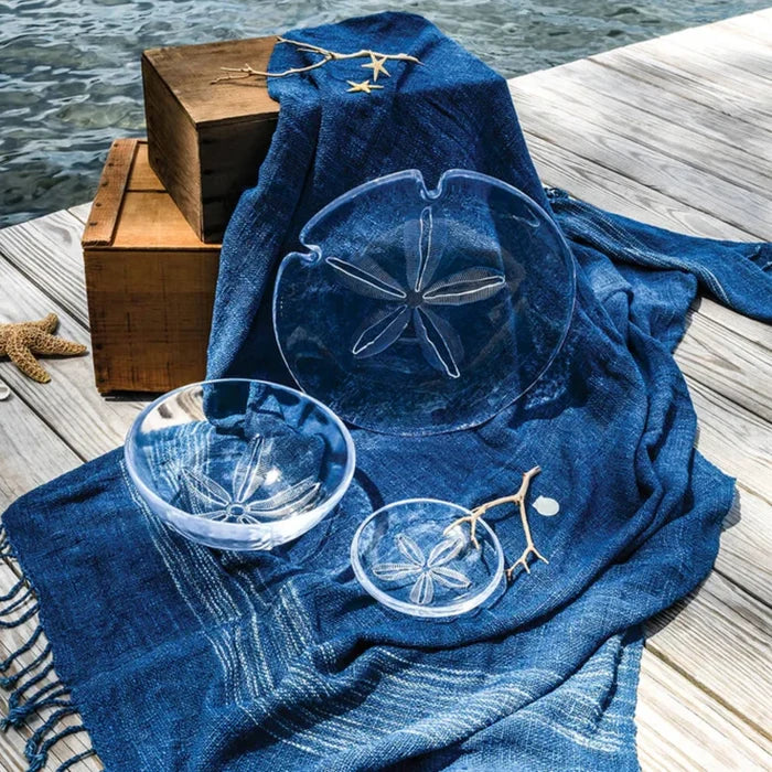 A dining table featuring two glasses, a basket, and a plate, arranged for a meal or gathering.