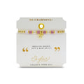 An elegant pink and gold bracelet with a bow detail, combining playful and sophisticated elements in its design.