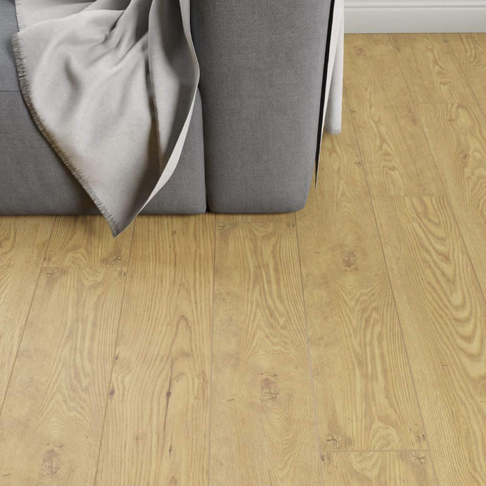 Tawny Chestnut Laminate Flooring in a living room setting with a sofa in the corner.