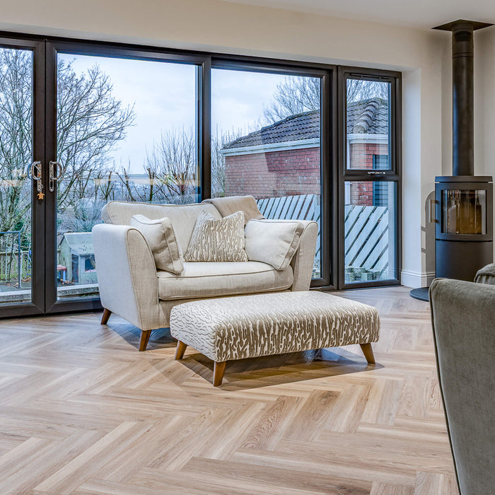 Volcanic Larch Rigid LVT Herringbone flooring in a kitchen lounge setting.