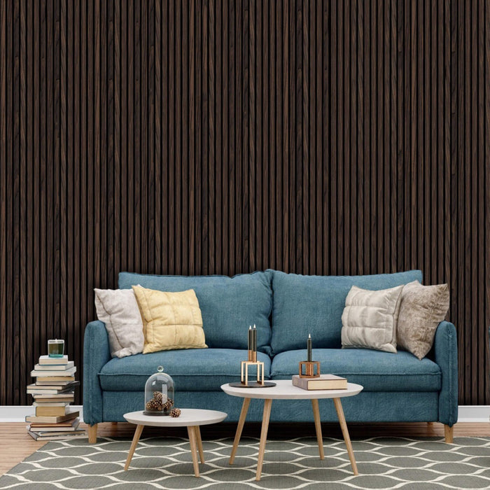 Blue sofa with decorative pillows in a living room setting with walnut slatwall.