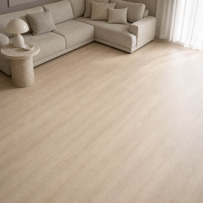 Washed Oak Essentials laminate flooring with a beige sofa in a living room setting.